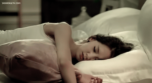 Yoona rolling around on a bed